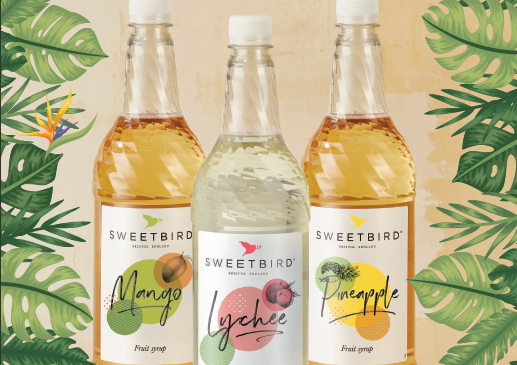 Three bottles of Sweetbird tropical fruit syrups on a leafy background